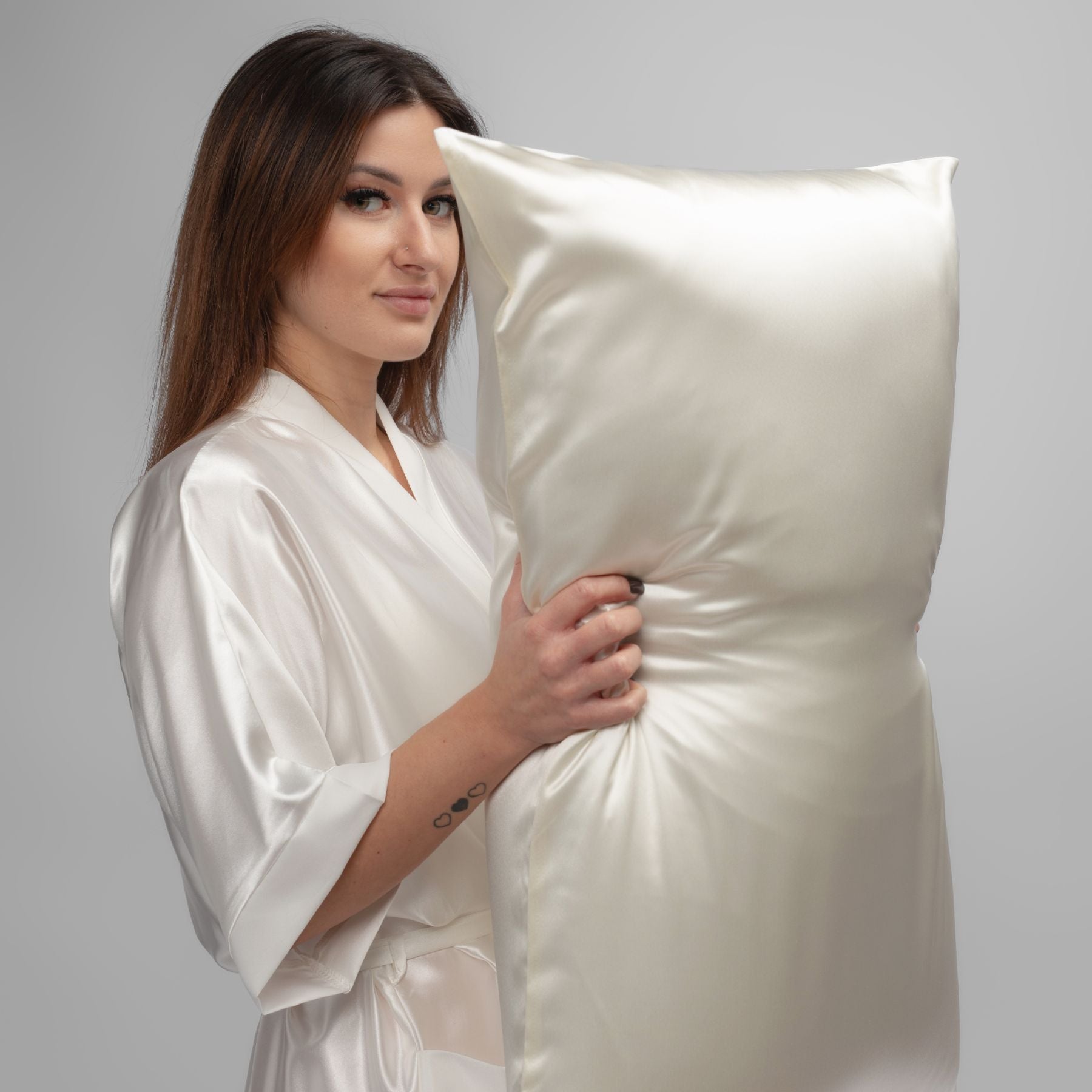 Woman resting on a pure mulberry silk pillowcase showing smooth texture, natural sheen, and luxury comfort benefits of silk
