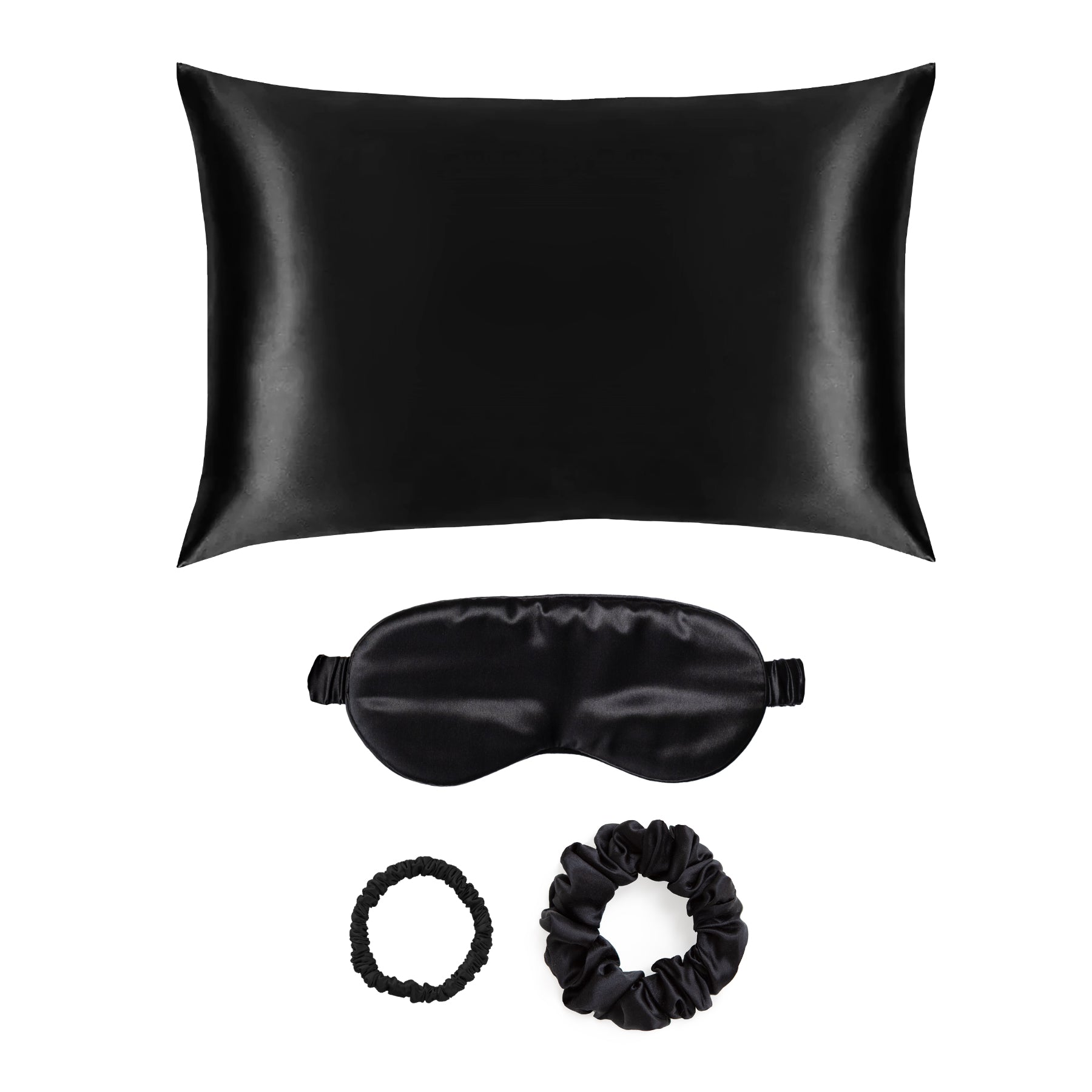 Black silk pillow, eye mask, and hair ties gift set on a white background