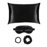 Black silk pillow, eye mask, and hair ties gift set on a white background