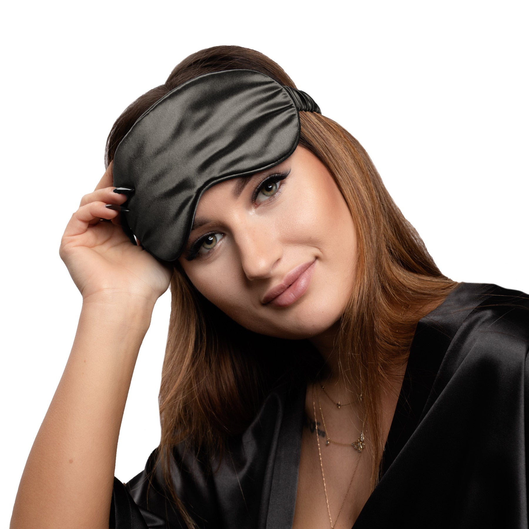 Woman wearing a charcoal silk eye mask on a white background