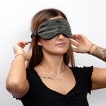 Woman wearing a Charcoal silk sleep mask against a white background