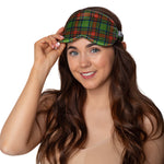 Woman wearing a green plaid sleep mask against a plain background