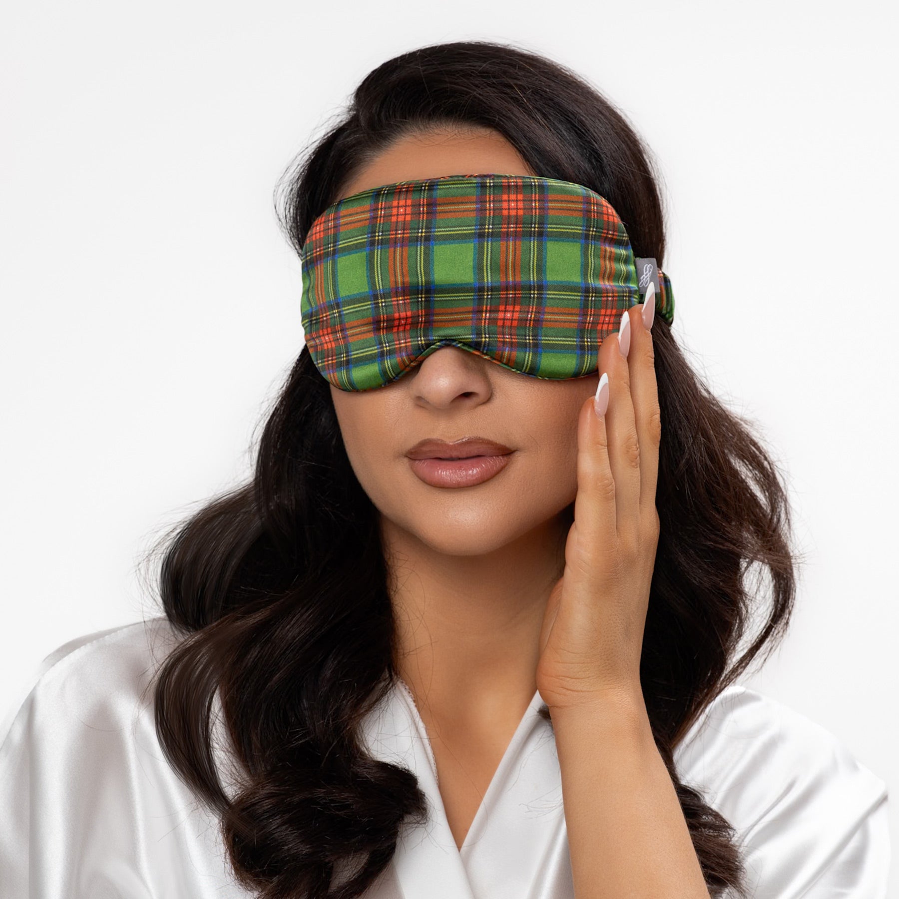 Woman wearing a plaid sleep mask on a white background