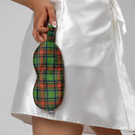 Green tartan silk eye mask held by a person wearing a white satin robe.