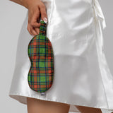 Green tartan silk eye mask held by a person wearing a white satin robe.