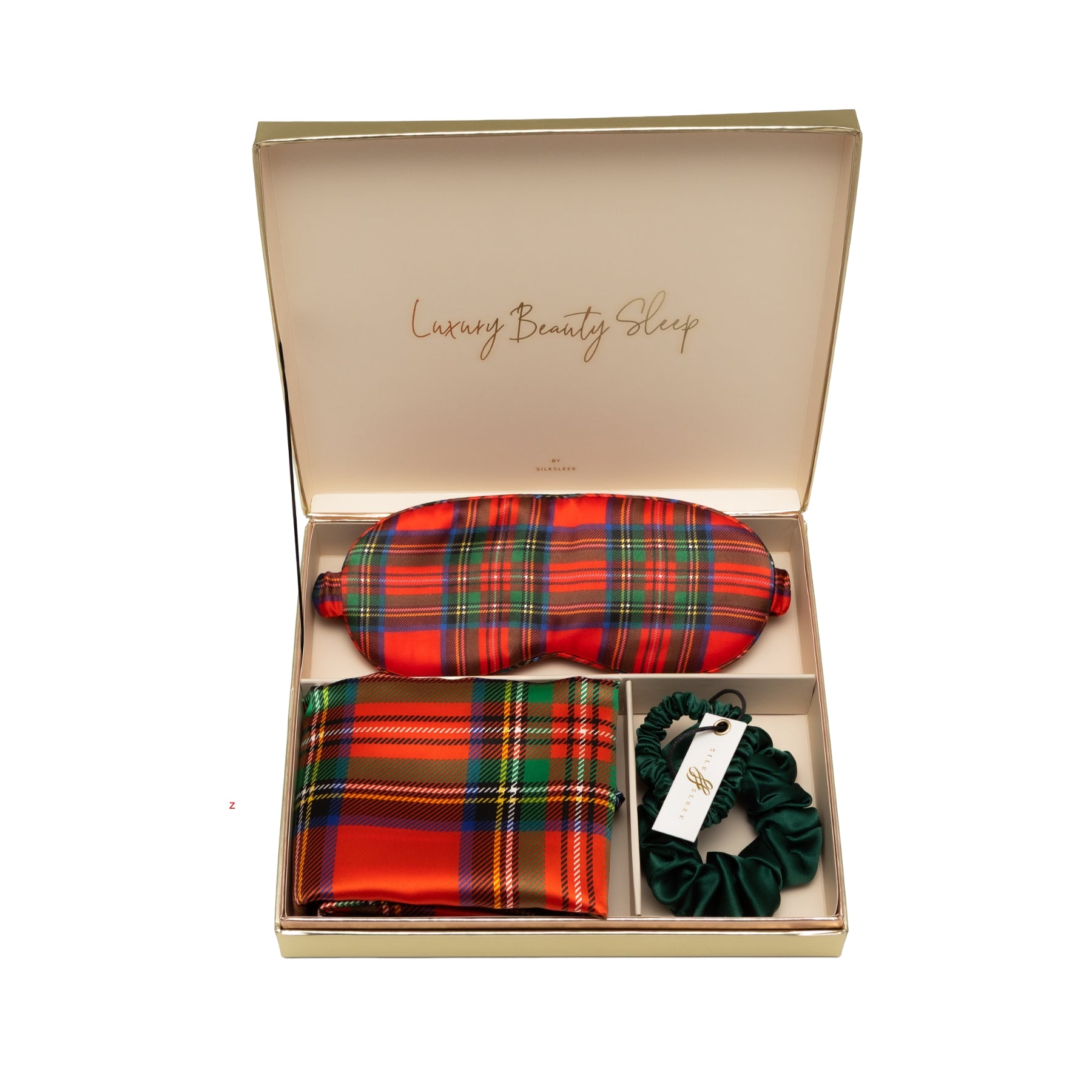 Red tartan silk sleep set with matching pillowcase, eye mask and emerald scrunchies displayed on a white background.
