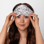 Woman wearing a gray leopard print silk sleep mask 