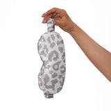 Hand holding a leopard print silk eye mask