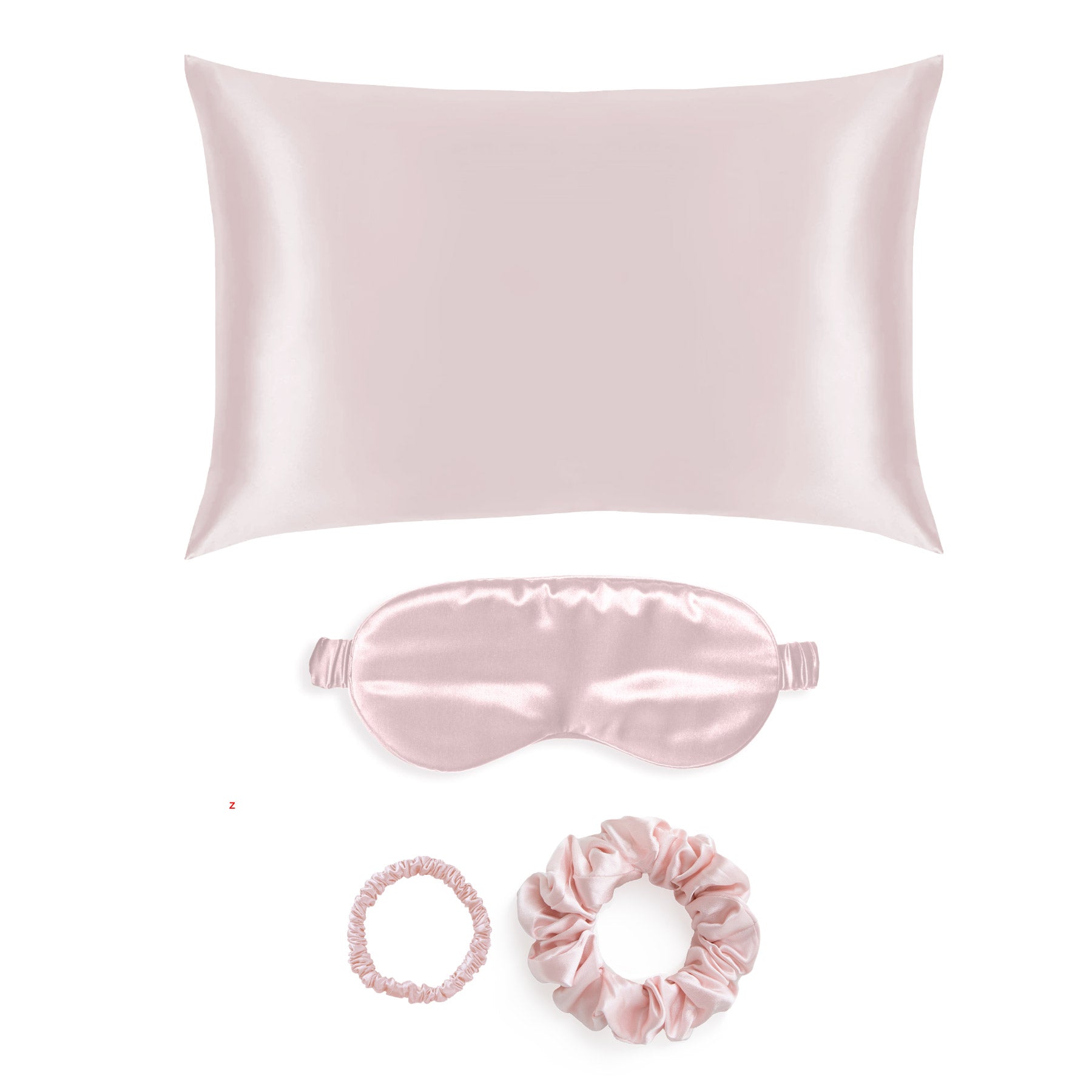Gift Set of pink silk  pillowcase, eye mask,  and scrunchie on a white background