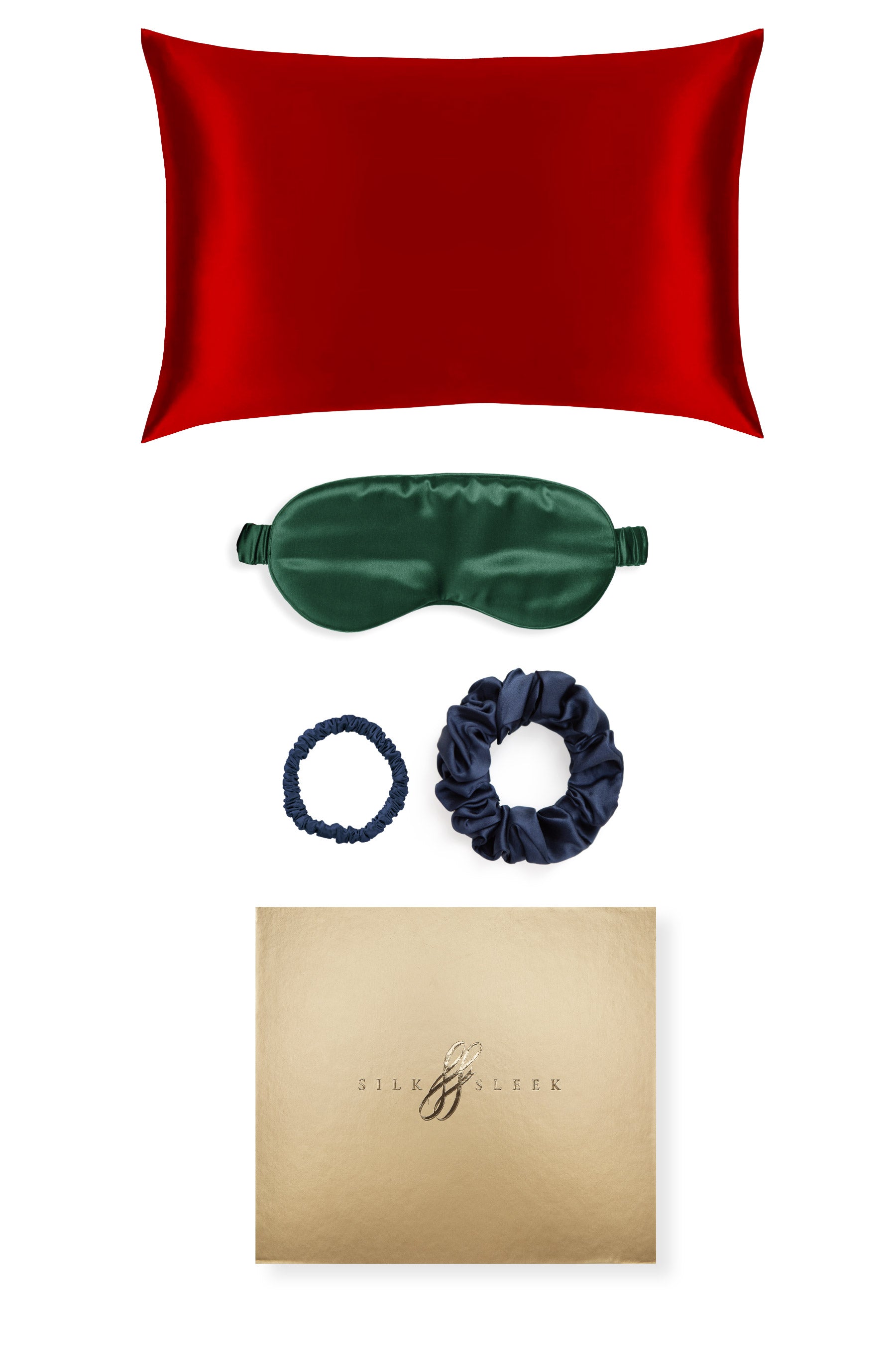 Red silk pillowcase, green eye mask, blue scrunchies, and gold box with brand logo on a white background