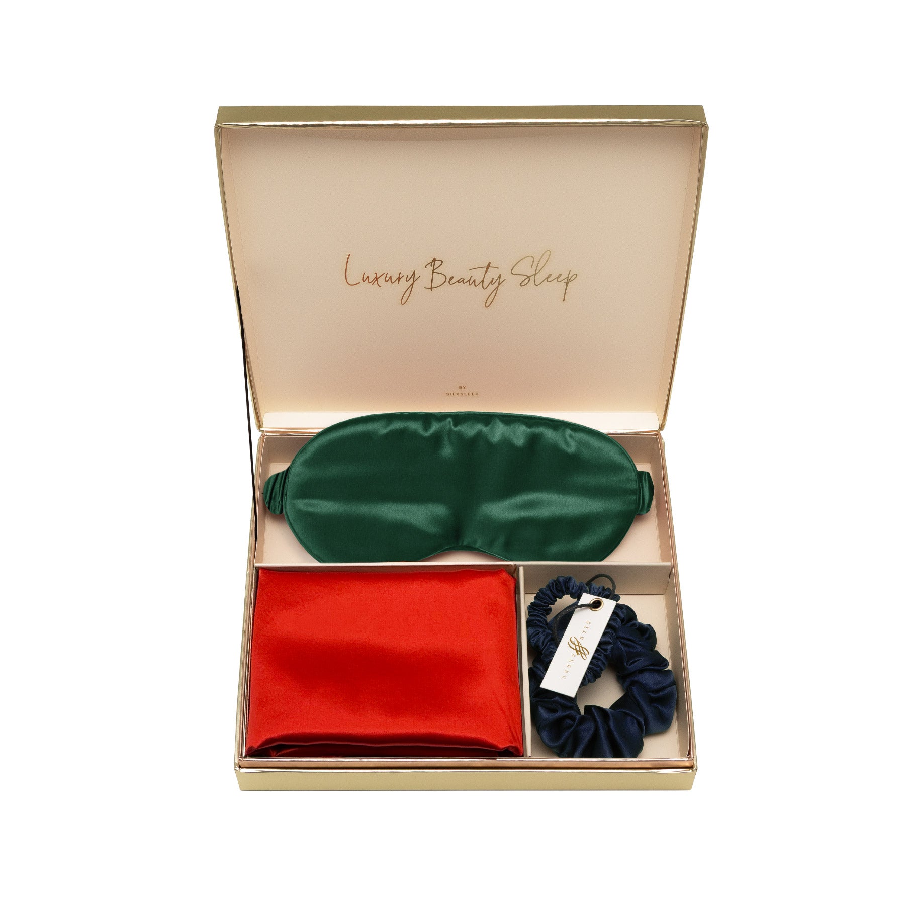 Set of green silk eye mask, red silk pillowcase, and navy scrunchies in a 'Luxury Beauty Sleep' box.
