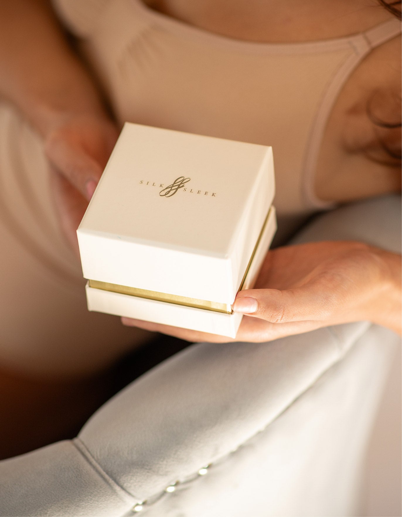 Person holding a white silk scrunchies gift  box